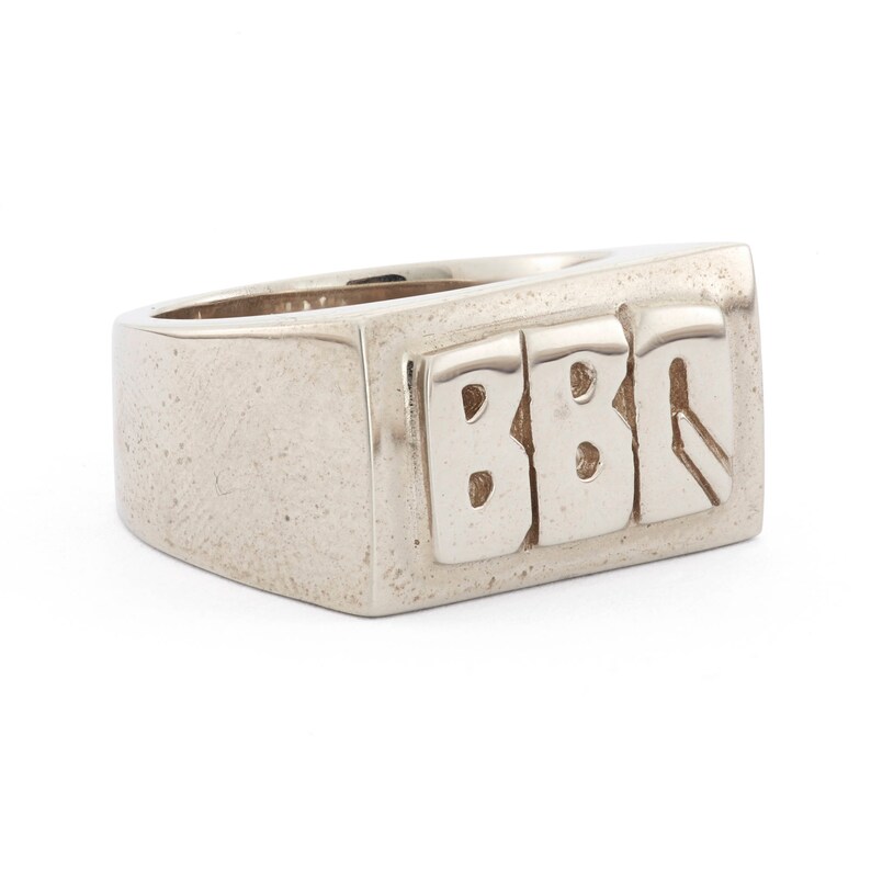 Peut inclure: Une bague signet en argent avec les lettres "BBQ" grav&eacute;es sur le dessus.