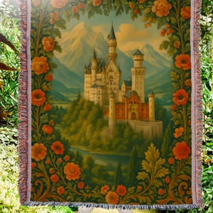 Può includere: Coperta arazzo tessuta con un dipinto dettagliato di un castello in un paesaggio montano. L'opera d'arte è incorniciata da un bordo di fiori arancioni e fogliame verde, con un bordo a frange.