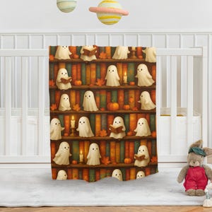 Può includere: Una coperta a tema Halloween con un design a libreria. Presenta fantasmi dei cartoni animati, zucche, candele e foglie d'autunno. I fantasmi sono in diverse pose, alcuni leggono libri. La tavolozza dei colori include arancione, marrone e crema.