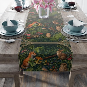 May include: A detailed table runner featuring a forest scene with foxes, owls, rabbits, and mushrooms. The design is predominantly green with accents of orange, brown, and red. The runner is placed on a wooden table, set with tableware and wine glasses.