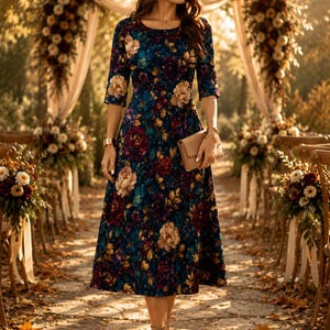 May include: A midi-length dress with three-quarter sleeves featuring a dark blue base with a multi-colored floral print in shades of burgundy, gold, and teal. The dress is paired with a tan wide-brimmed hat, tan ankle boots, and a tan clutch.
