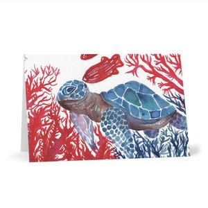 May include: Watercolor greeting card featuring a blue sea turtle swimming among red coral and blue seaweed. The turtle has a patterned shell and is set against a white background. The card is blank inside.