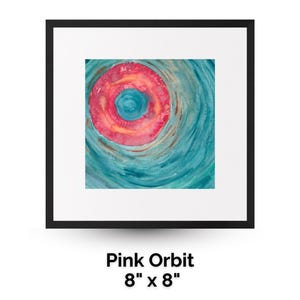May include: Square framed artwork titled "Pink Orbit" featuring a watercolor painting. The painting has a central pink and yellow circle with a blue centre, surrounded by swirling teal brushstrokes. The artwork measures 20cm x 20cm.