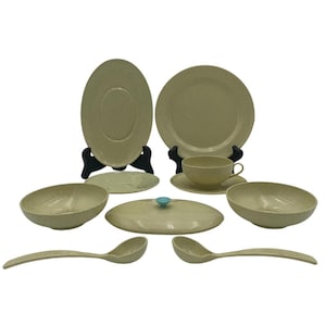 May include: A set of beige-colored, melamine dinnerware, including two large plates, two bowls, a lidded dish, a small bowl, a saucer, and two spoons.