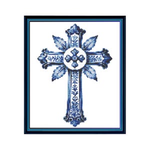 Pode incluir: Uma obra de ponto cruz emoldurada apresentando um design de cruz central em azul e branco. A cruz é adornada com padrões florais intrincados e motivos de folhas, centralizada dentro de um elemento circular, tudo em uma moldura azul escura.