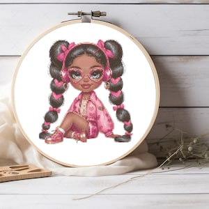 Puede incluir: Un patrón de punto de cruz con una niña de dibujos animados con auriculares rosas, una chaqueta rosa y coletas. Lleva gafas rosas y tiene la piel morena.