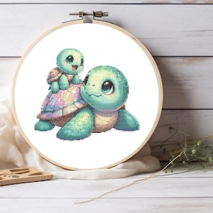 Puede incluir: Un patrón de punto de cruz con dos adorables tortugas de dibujos animados. La tortuga más grande es verde con un caparazón rosa y azul, y la tortuga más pequeña está montada en su espalda. Las tortugas tienen ojos grandes y expresiones dulces.