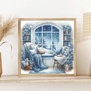 Puede incluir: Un patrón de punto de cruz que representa una acogedora escena de sala de estar con una ventana que da a un paisaje nevado. La habitación cuenta con un cómodo sillón con una manta, una mesa auxiliar con una taza y un libro, y una estantería llena de libros. La ventana es arqueada y tiene una vista de un bosque nevado y un cielo estrellado.