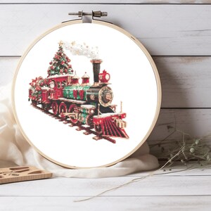 May include: A red and green Christmas train with a Christmas tree on top. The train is decorated with lights and ornaments. The train is on a white background.