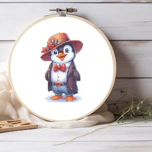 May include: A cross-stitch pattern of a penguin wearing a brown hat with red flowers, a white shirt, a red bow tie, and a brown jacket. The penguin is standing on a white background.
