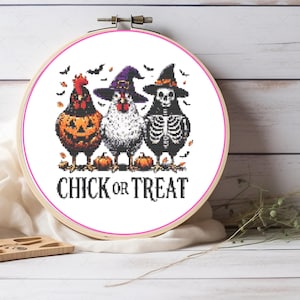 May include: A cross-stitch embroidery hoop featuring three chickens in Halloween costumes. One is a jack-o'-lantern, one wears a witch hat, and the last is a skeleton. The text "CHICK OR TREAT" is below the chickens.