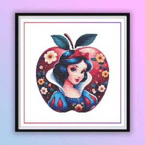 Puede incluir: Impresión artística enmarcada que presenta un retrato de una mujer con cabello oscuro y un vestido azul, dentro de un diseño de manzana roja. La manzana está adornada con flores y hojas verdes, creando una ilustración caprichosa y colorida.