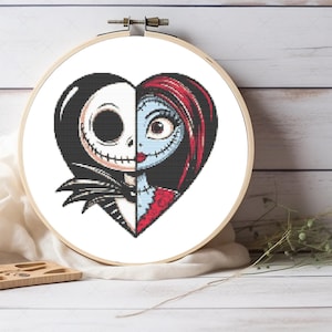 May include: A cross-stitch embroidery hoop with a heart design split in two. One half shows Jack Skellington, the other Sally, from The Nightmare Before Christmas. The design uses black, white, red, and blue, set against a light wood background.