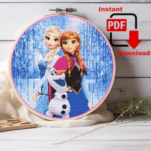May include: A cross-stitch embroidery hoop featuring a design of Elsa, Anna, and Olaf from the movie Frozen. The characters are depicted in a pixelated style, with a blue and white background. The text "Instant PDF Download" is visible.