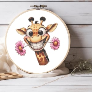 May include: A cross-stitch pattern of a cartoon giraffe with a big smile holding two pink flowers in its mouth.