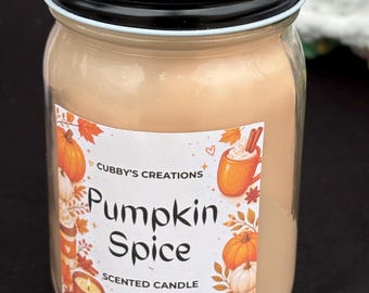 May include: A clear glass jar candle with a black lid, filled with light tan wax. The label reads Cubby's Creations Pumpkin Spice Scented Candle 11 oz / 312 g, decorated with illustrations of pumpkins, cinnamon sticks, and mugs of warm beverages.