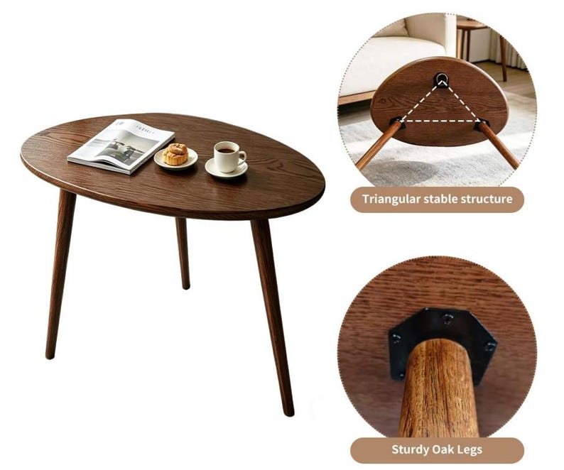 Puede incluir: Una mesa auxiliar de madera marr&oacute;n oscuro con tablero ovalado y tres patas c&oacute;nicas. La mesa presenta una estructura triangular estable y patas de roble resistentes fijadas con herrajes met&aacute;licos negros. Un libro, un pastel y una taza encima.