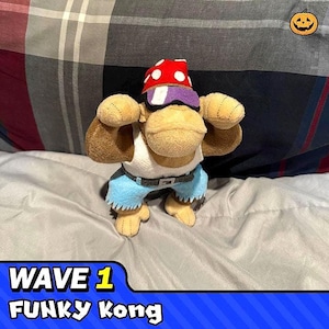 Pode incluir: Um brinquedo de pelúcia do Funky Kong da série Donkey Kong. Ele está usando um chapéu vermelho e branco, óculos de sol, uma camiseta branca sem mangas e shorts azuis. O brinquedo está em pé em um cobertor cinza e branco. O texto "WAVE 1 FUNKY KONG" é visível na parte inferior da imagem.