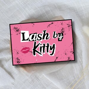 Pu&ograve; includere: Un cartello rettangolare rosa con la scritta "Lash by Kitty" in un carattere audace e stilizzato. Il cartello presenta uno sfondo rosa con schizzi neri e un marchio di bacio di rossetto rosso. Il cartello &egrave; posto su uno sfondo neutro.