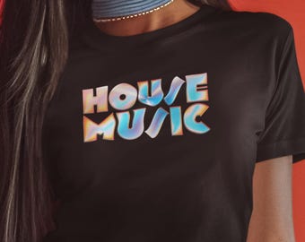 May include: Black crop top with the words "HOUSE MUSIC" in a colorful, iridescent font. The text has a gradient effect with shades of blue, pink, and yellow. The shirt is a solid black color.