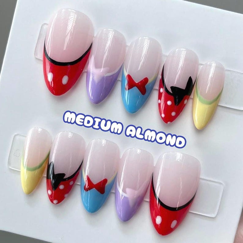 May include: Set of ten medium almond-shaped false nails with a white tip and various Disney character designs. The designs include Mickey Mouse, Minnie Mouse, and Snow White. The text "MEDIUM ALMOND" is printed on the white background.