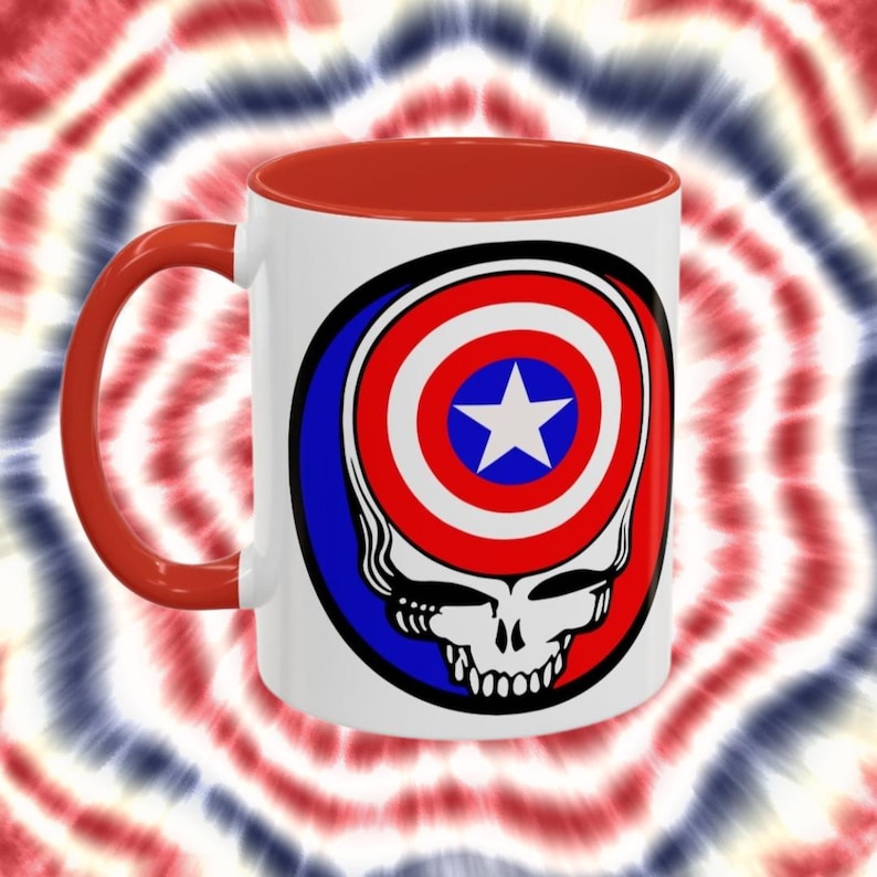 May include: White ceramic coffee mug with a red interior and handle. The mug features a graphic of a skull with the American flag inside the skull's head.