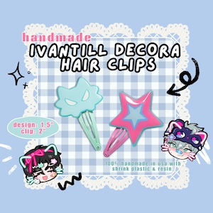 Op de afbeelding: Handgemaakte IVANTILL Decora haarclips. De afbeelding toont drie haarclips: een lichtblauwe katvormige clip, een roze stervormige clip en een cartoonkarakterclip. Het ontwerp is 3,8 cm, en de clip is 5,1 cm. Gemaakt in de VS met krimpfolie en hars.