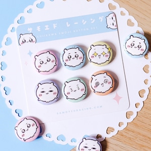 May include: A set of eight colorful round enamel pins featuring a cute bear-like character with various facial expressions. The pins are on a white card with Japanese text and a website address. The pins are in pastel colors.
