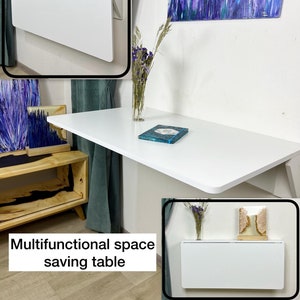 Mesa dobrável de parede com prateleiras, design que economiza espaço.