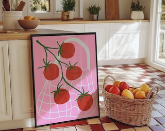 Op de afbeelding: Een roze en witte illustratie van een tros rode tomaten in een netzak. De illustratie is ingelijst en hangt aan een witte muur in een keuken.