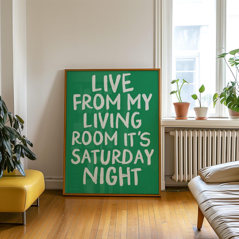 May include: A green framed poster with white text that reads "Live from my living room it's Saturday night".