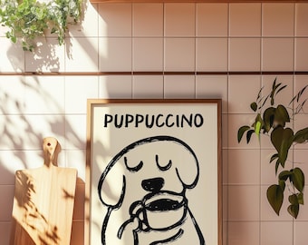 Puede incluir: Una impresión enmarcada con una ilustración en blanco y negro de un perro sosteniendo una taza de café. El texto "PUPPUCCINO" está escrito en negro en la parte superior de la impresión.