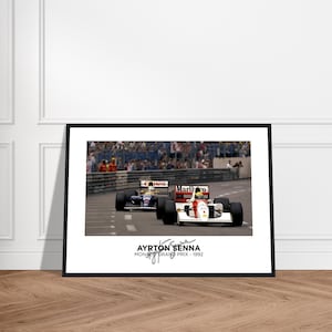 May include: Framed photograph of a Formula 1 race featuring two cars racing on a track. The lead car is white and red with "Marlboro" branding. The photograph is labeled "Ayrton Senna Monaco Grand Prix - 1992".