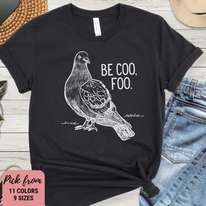 May include: Black t-shirt with a white drawing of a pigeon and the text "Be Coo, Foo."