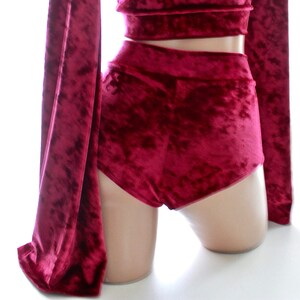 May include: A set of red velvet shorts and a matching top. The shorts are high-waisted and have a wide leg. The top is a crop top with long sleeves.