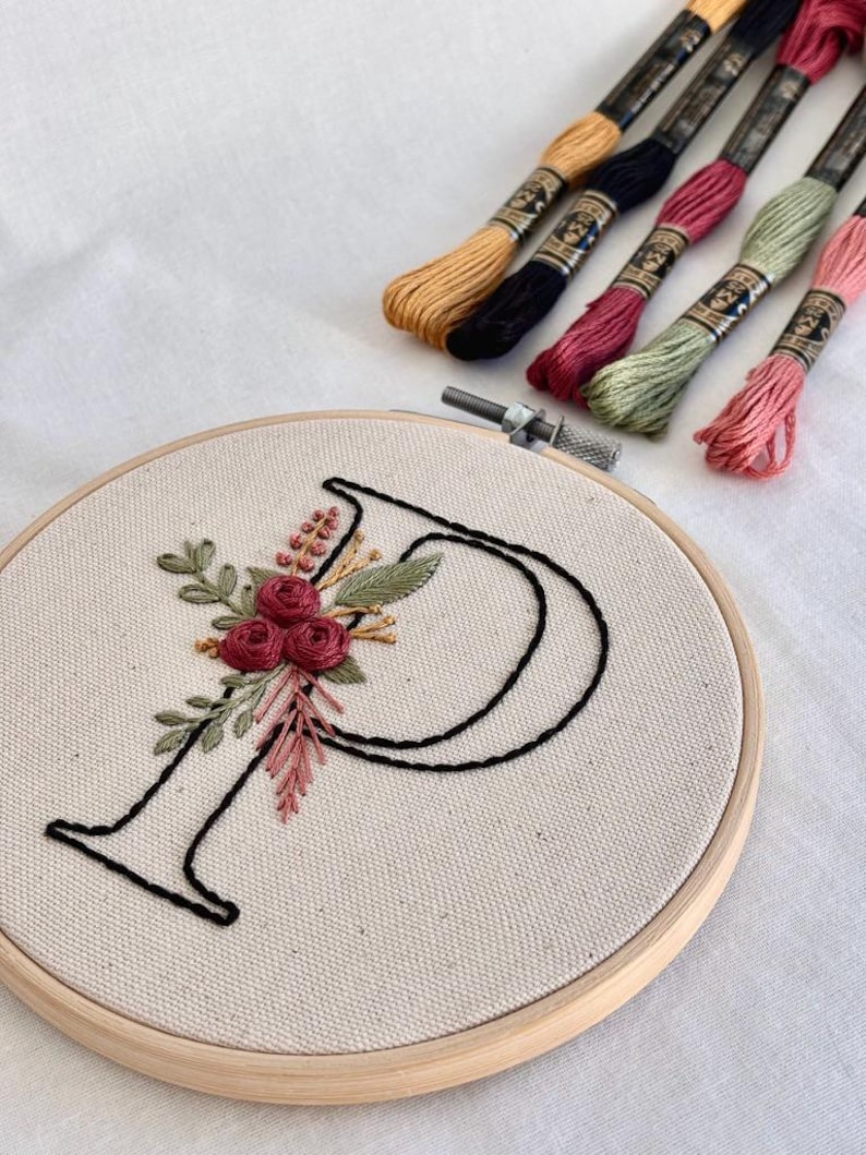 Floral monogram embroidery pattern featuring elegant letter designs with stitched flowers and leaves, full alphabet embroidery bundle A to Z, printable hand embroidery patterns, beginner friendly embroidery designs with step by step stitch guide and color references