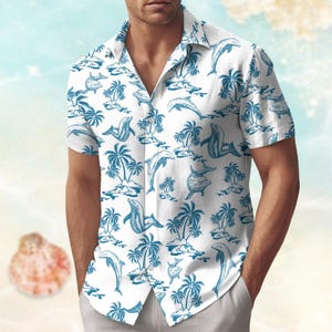 May include: White button-down shirt with a blue dolphin and palm tree pattern. The short-sleeved shirt features a classic collar and a relaxed fit, perfect for a casual, tropical look. The design includes illustrations of dolphins, palm trees, and small islands.
