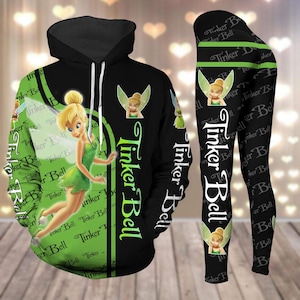 Puede incluir: Conjunto de sudadera con capucha y leggings negro y verde con Tinker Bell y el texto "Tinker Bell" repetido en todo.