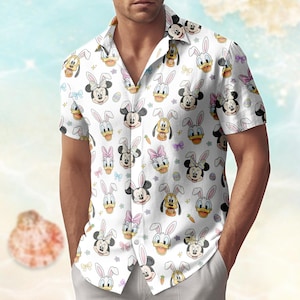 May include: White button-down shirt featuring a repeating pattern of cartoon characters wearing bunny ears, including Mickey and Minnie Mouse, Donald Duck, and Pluto. The shirt has short sleeves and a classic collar, perfect for a casual, festive look.