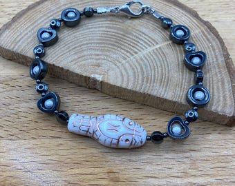 White snake head glass bead bracelet with hematite heart donuts and white miracle beads suspended within