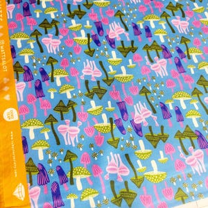 May include: Blue fabric with a repeating pattern of colorful mushrooms in pink, green, purple, and brown. The fabric has a light blue background. The fabric is 100% cotton and made in Japan.