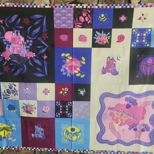 May include: A patchwork quilt featuring a variety of whimsical designs in a grid pattern. The quilt showcases illustrations of castles, butterflies, flowers, and geometric shapes in shades of pink, purple, blue, and yellow against black and cream backgrounds.