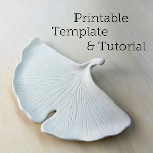 May include: A white, leaf-shaped ceramic dish with detailed vein patterns. The dish has a smooth, matte finish and is set against a light-colored wooden surface. Text on the image reads "Printable Template & Tutorial".
