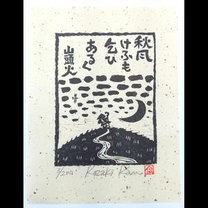 以下が含まれることがあります： 黒と白の木版画、斑点のある紙に印刷。丘の上の人物、曲がりくねった道、三日月、日本語のテキストが描かれています。この版画は署名入りで、3/200と番号が付けられています。