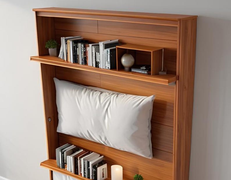 Peut inclure: Une t&ecirc;te de lit en bois avec des &eacute;tag&egrave;res int&eacute;gr&eacute;es pour les livres et les objets d&eacute;coratifs. La t&ecirc;te de lit est de couleur brun clair et comporte un oreiller blanc.