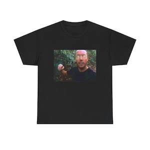 May include: Black t-shirt featuring a printed image of a person in a forest setting. The image on the shirt shows a man with a forest background. The t-shirt is made of a soft, comfortable material.