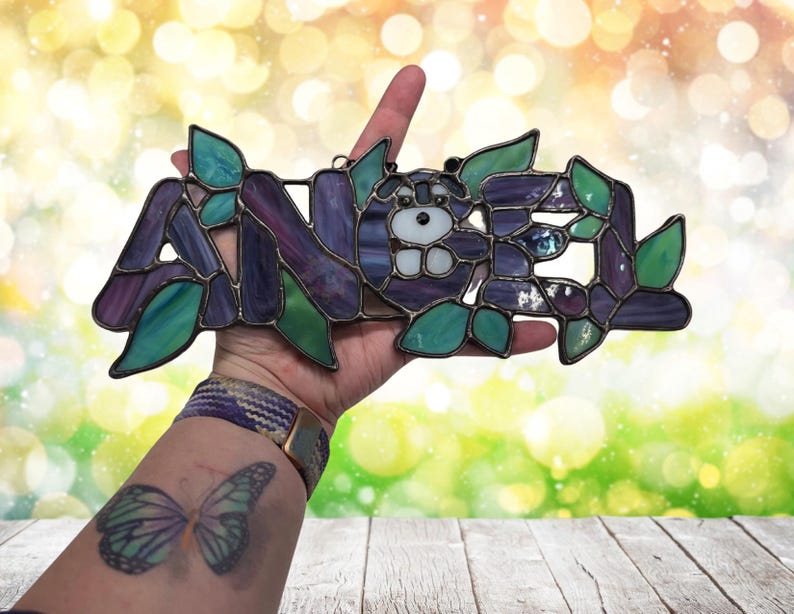 Baby name "Angel" being held to show size. A five letter name will be approximately  7" wide and 5" high.