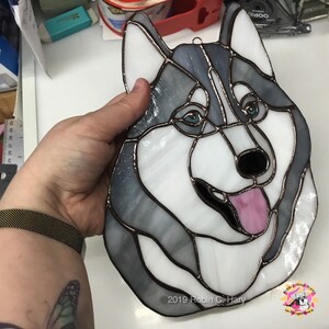 Siberian Husky Suncatcher being held for size reference.