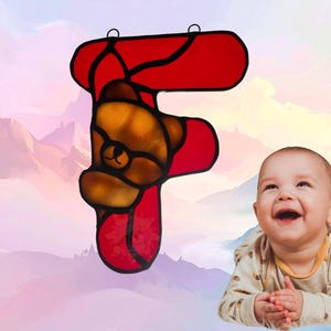 Alphabet letter- F- shown with Bear Cub. Letter is made of red glass while the bear is amber/brown. Bear cub represents February.