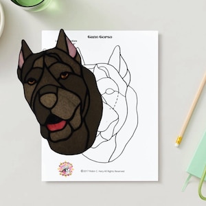 Könnte beinhalten: Ein Cane Corso-Porträt im Glasmalerei-Stil, in Braun- und Schwarztönen, mit roter Zunge. Das Bild befindet sich auf weißem Papier mit einer Strichzeichnung des Hundekopfes. Ein Bleistift, Schlüssel und ein Notizblock sind ebenfalls zu sehen.